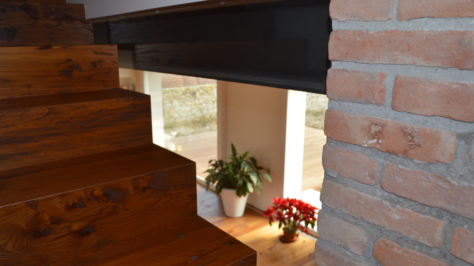 Scala in legno e parete in mattoni, dettaglio di progettazione architettonica degli interni